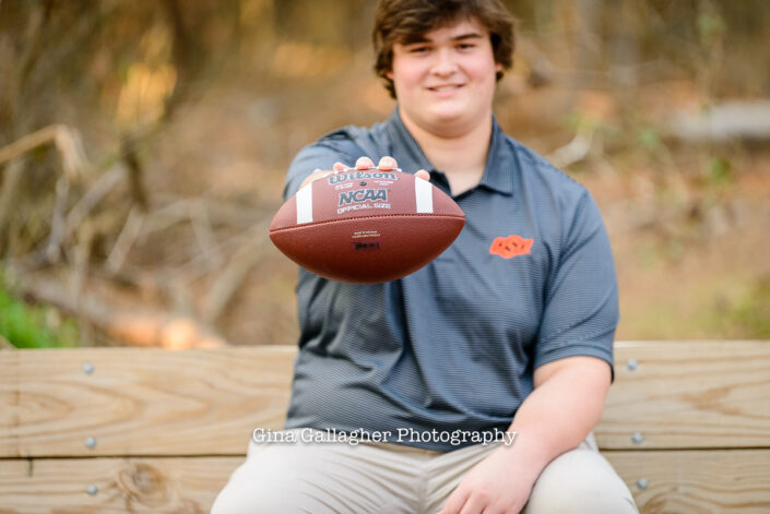 Senior guy holding out a football